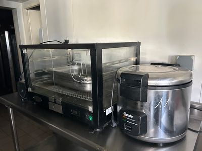 stainless steel counter top with a crock pot and a microwave on it
