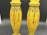 une paire de vases jaunes posés sur une table noire