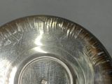 a silver bowl on a table with a black background