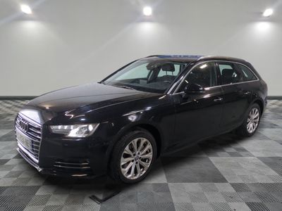 L'Audi break noire est garée dans une grande pièce.