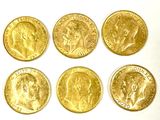 six different types of gold coins are shown on a white surface