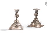 paire de bougeoirs anciens en argent sur un socle, sur fond blanc