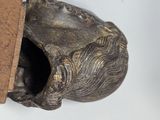 a small statue of a frog with a book in it ' s mouth