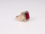 Gros plan sur une bague en or ornée d'une pierre rouge