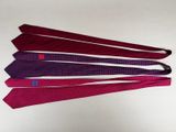 four ties are arranged in a row on a white surface