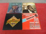 trois vinyles de Ray Charles et de son groupe posés sur une table rouge