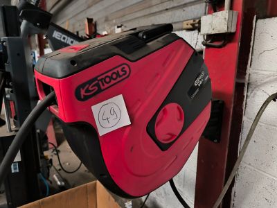 an image of a red and black air compressor in a garage