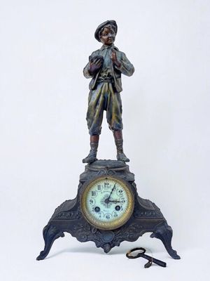 a statue of a man standing on top of a clock next to a pair of scissors