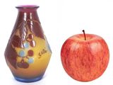 an apple and a vase sitting next to each other
