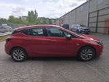 a red car parked in a parking lot next to a building