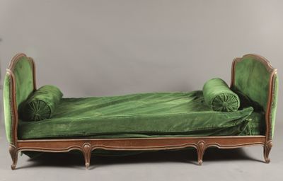 un lit recouvert d'un couvre-lit vert et sur lequel sont posés des oreillers