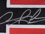 a close up of a black and red jersey with a signature on it