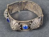 un gros plan sur un bracelet en argent orné de pierres bleues