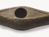 un objet en pierre qui ressemble à un rocher percé d'un trou