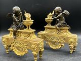 paire de figurines anciennes en bronze représentant des chérubins, posées sur une table