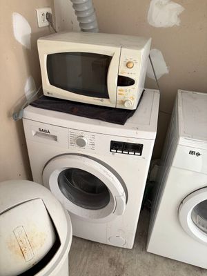 deux machines à laver et un sèche-linge dans un coin de la pièce