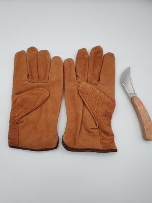 two pairs of gloves and a hammer on a white surface
