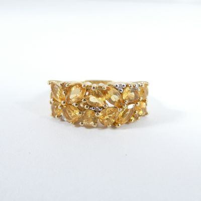 bague en or jaune sertie de diamants sur fond blanc