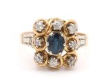 a close up of a blue sapphire and diamond ring on a white background