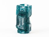 un vase bleu orné d'un visage, posé sur une surface blanche