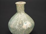 a green vase that is sitting on a black surface