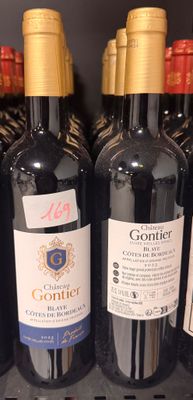 several bottles of wine are lined up on a shelf in a store