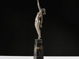 an art deco sculpture of a woman holding a tennis racquet