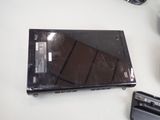 a broken laptop sitting on a table next to a charger