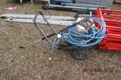 un petit chariot posé au sol, auquel est fixé un tuyau