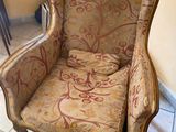 an old chair with a floral upholstered seat in a room