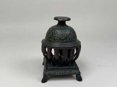 an antique bronze incense burner with a green patt finish