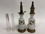 paire de lampes anciennes en porcelaine, avec des ferrures en laiton et un tube en verre transparent
