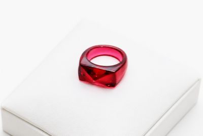 une image représentant un anneau rouge posé sur une boîte blanche