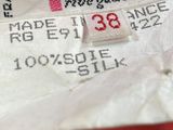 an image of a label on a red dress with a white shirt underneath it
