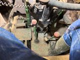a man that is working on a machine in a barn