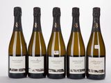 quatre bouteilles de vin sont alignées sur une surface blanche
