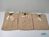 three t - shirts with tags on them sitting on a table