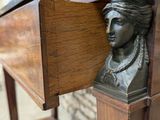 a bronze bust of a woman on a wooden table