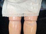 a close up of a doll ' s legs wearing knee pads