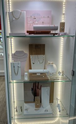 a glass display case with jewelry on it in a store