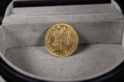 une pièce d'or posée dans une boîte sur une table