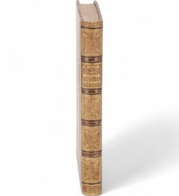 un vieux livre à la couverture brune posé sur une surface blanche