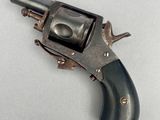 un vieux pistolet posé sur une surface blanche