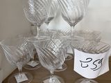 plusieurs verres à vin vides posés sur une étagère en bois