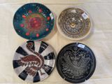 trois assiettes décorées, posées sur une table