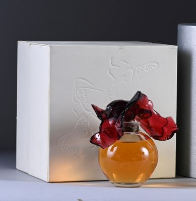 bottles of perfume sitting on a table next to a box