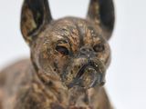 a small statue of a dog on a white surface