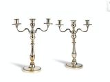 a pair of silver plated candlesticks on a white background