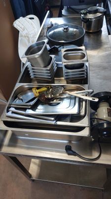de nombreuses casseroles et poêles posées sur le plan de travail de la cuisine