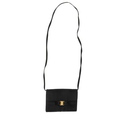 a black purse with a gold buckle and a long strap